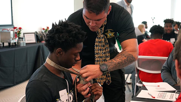 Tommy Bohanon teaching to tie a tie